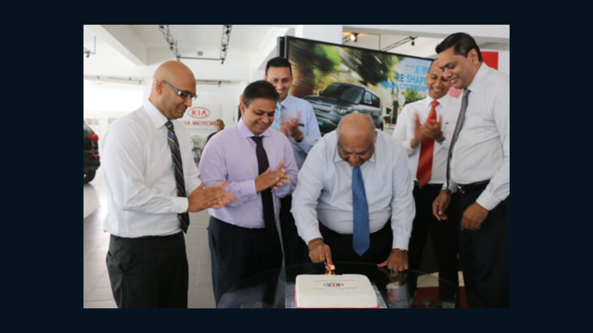 Mr. Mahen and other Kia employees cutting a cake
