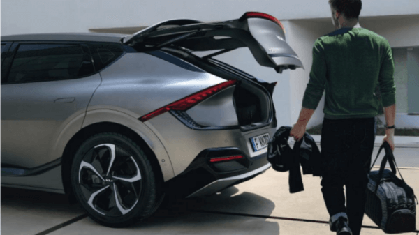 Man loading a bag in the trunk of a Kia EV6