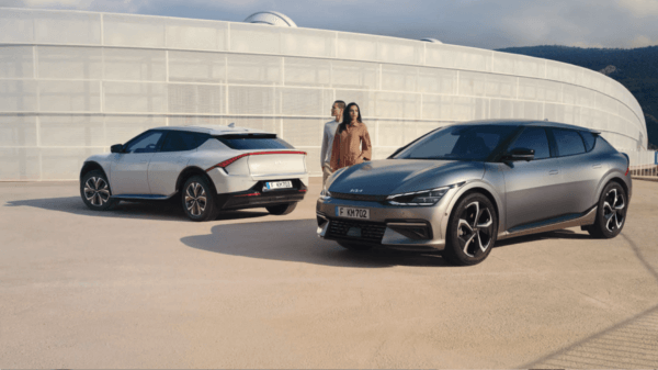 Two people next to Electric SUV Kia EV6